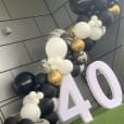 A black and gold balloon arch with a number 40 on it, available for Glow Numbers Hire.