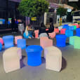 A group of colorful Glow Sphere chairs on a street at night.