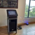 A computer with a Jukebox & Karaoke Hire package is sitting on a table in front of a window.