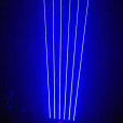 A blue light is shining on a stage in a dark room. Blue laser light illuminates the stage, creating a captivating atmosphere during events and performances.