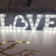 A large light up white letter 'love' on a white floor.