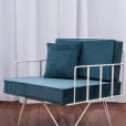 A wire lounge arm chair with green velvet cushions