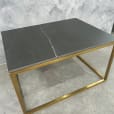 Rectangular Gold Coffee Table Hire next to a marble wall