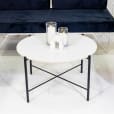 Black cross coffee table next to velvet lounge