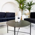 Black Cross Coffee Table next to velvet blue lounges
