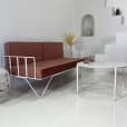 White Cross Coffee Table next to a brown wire lounge