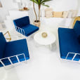 White round coffee table in the middle of a navy blue wire lounge setting