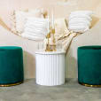 Two green velvet ottoman stools on display