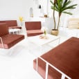 Pink velvet cushions on a white wire lounge chair