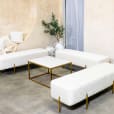 White velvet ottoman benches around a coffee table