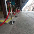 Close-up view of red velvet rope chrome bollard