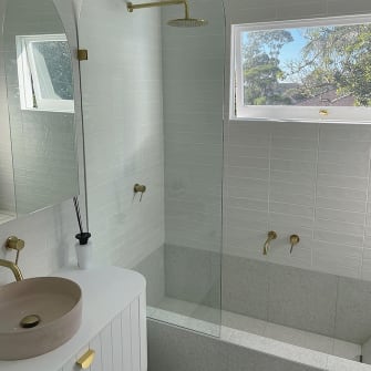 A stylish arched custom glass bath screen
