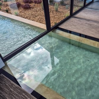 A glass floor in a business with water flowing under it