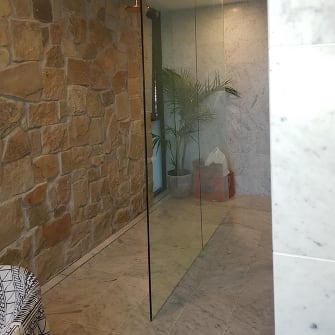 Elegant glass wall in front of a stonewall