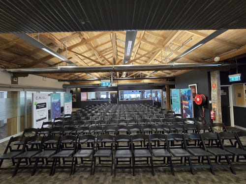 Hundreds of black plastic folding chairs at an indoor event