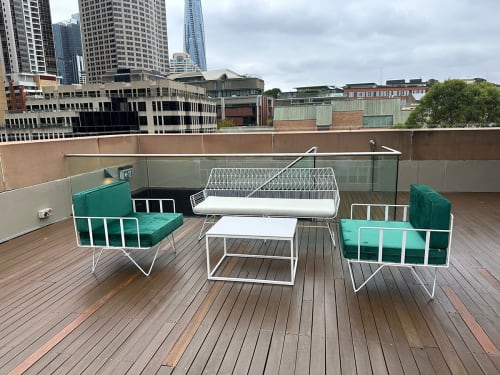 White sofa lounge with emerald green cushions on a rooftop