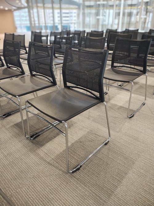 Black plastic conference chairs lined up and ready for a meeting