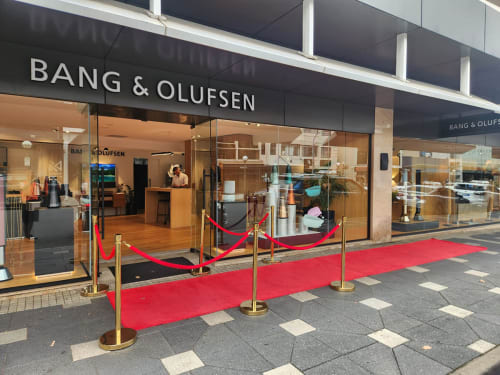 Brass gold bollards with red velvet rope and a red carpet