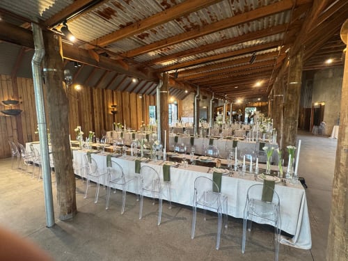 Tables and chairs beautifully set up for an indoor wedding reception