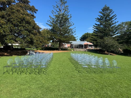 Over 100 Victorian ghost chairs set up for a wedding in a park