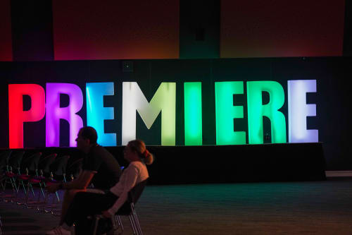 Large glow letters in multiple colours that spell 'PREMIER'