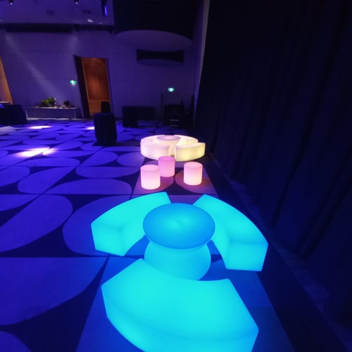 Two sets of glowing tables and stools