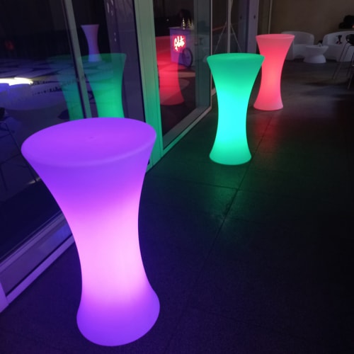 Three tall glowing stools at a night event