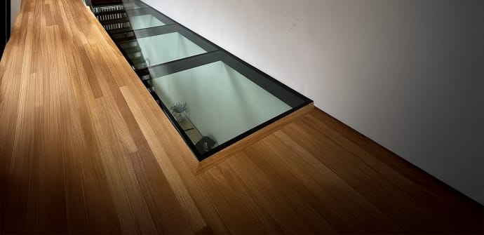A wooden floor with a new glass floor installation