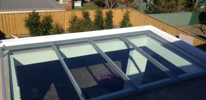 A residential glass roof overlooking a backyard