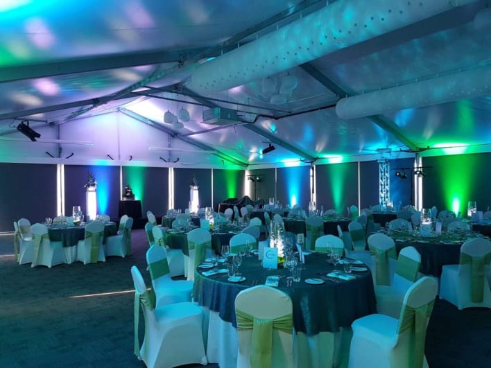 A large tent with green and blue lighting.