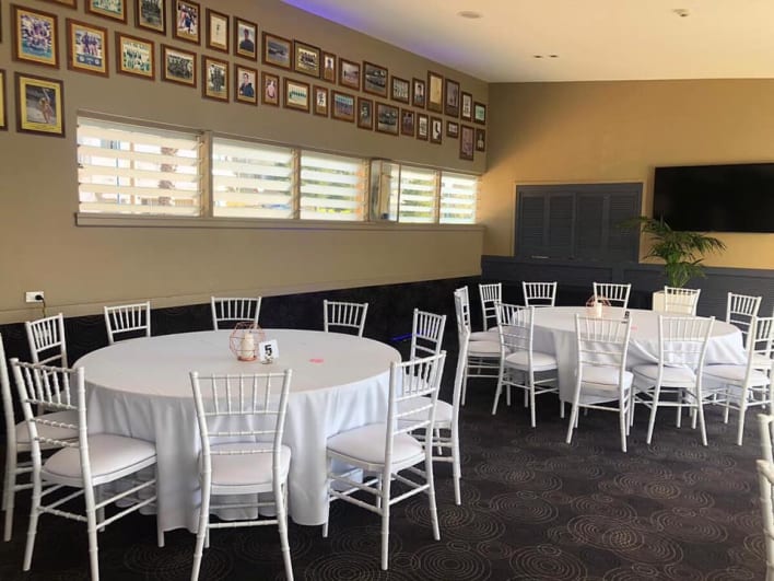 A room with tables and chairs set up for a party.