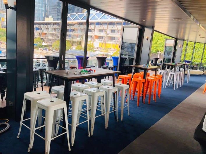 A bar with tables and stools in the middle of a room.