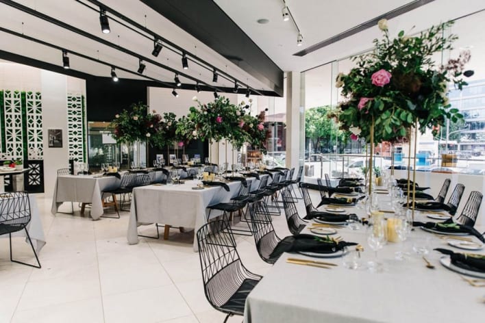 A restaurant with tables and chairs set up for a wedding reception.