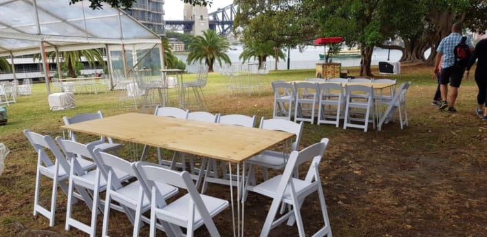 A white table and chairs set up in a grassy area.