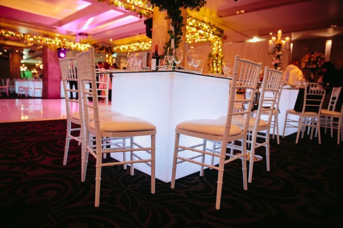 A white table and chairs in a room with lights.