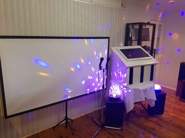 A dj set up in a room with lights and a projector.
