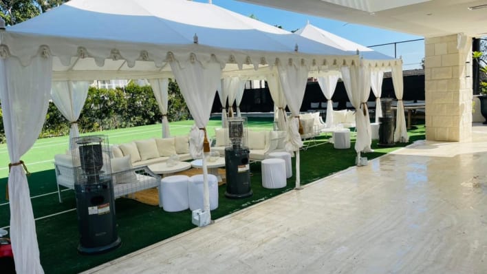 A white tent set up on a grassy area.