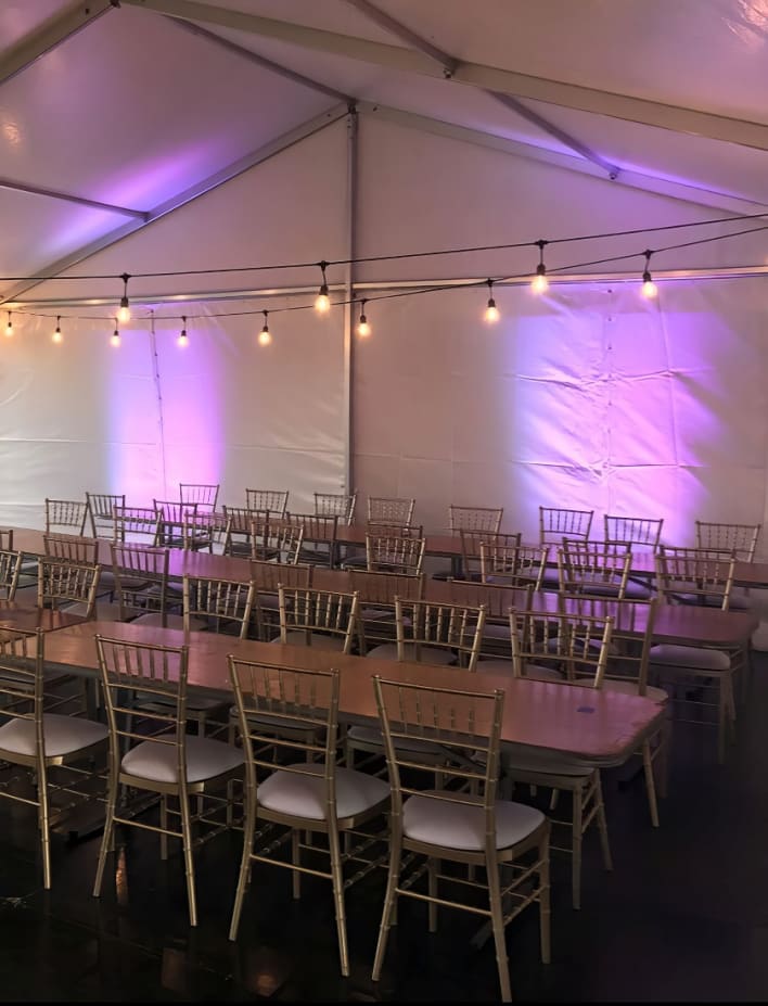 A tent set up with tables and chairs.