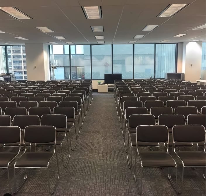 An empty conference room with rows of chairs.