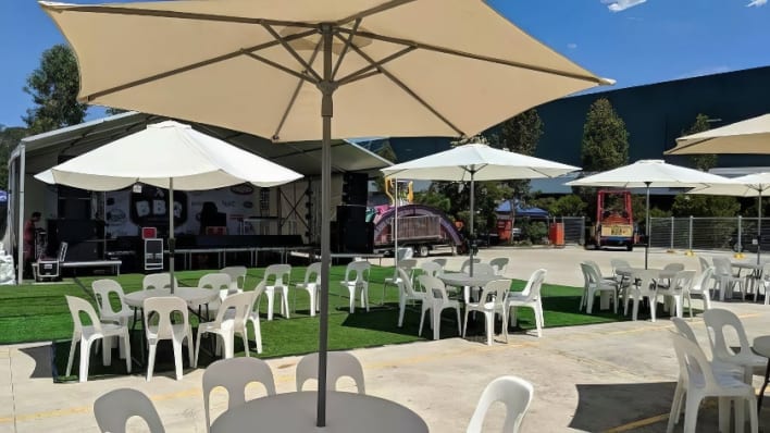 An outdoor area with tables and chairs and umbrellas.