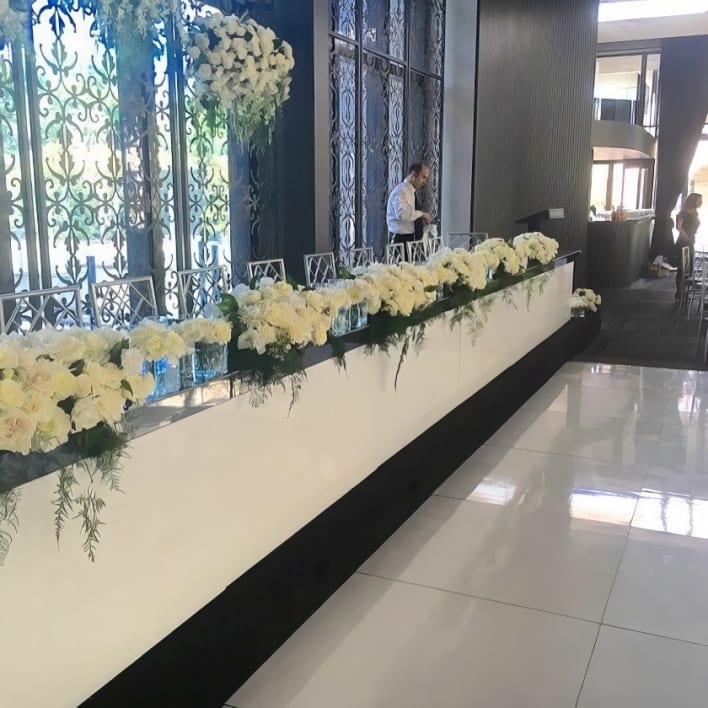 White flowers on a table in a hotel lobby.