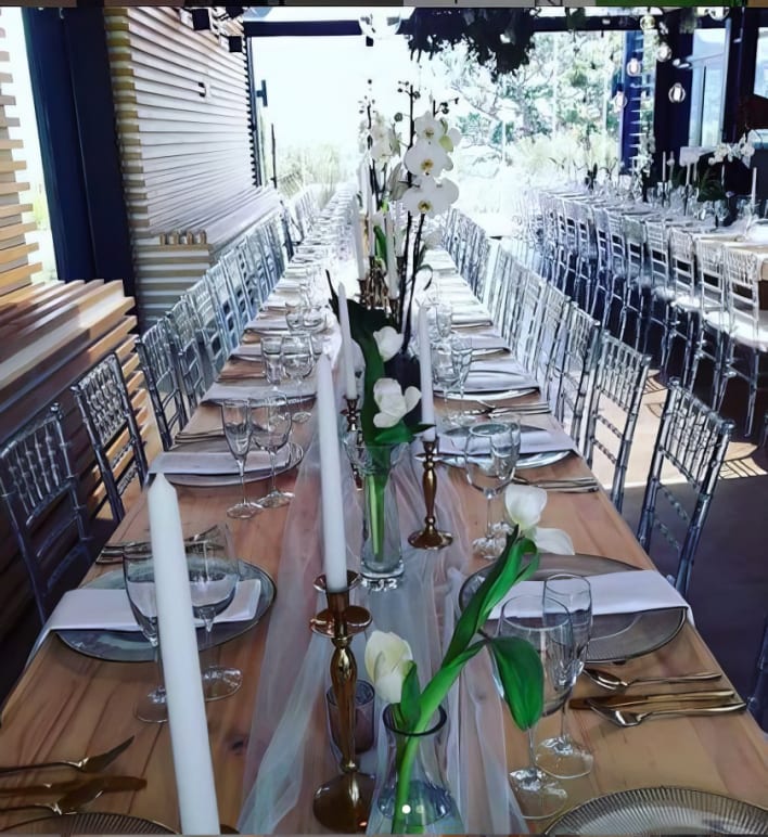 A long table set up with flowers and vases.