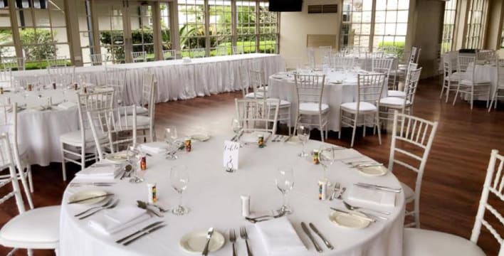 A room with tables and chairs set up for a wedding.