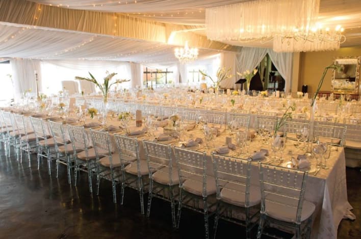 A large room with tables and chairs set up for a wedding.