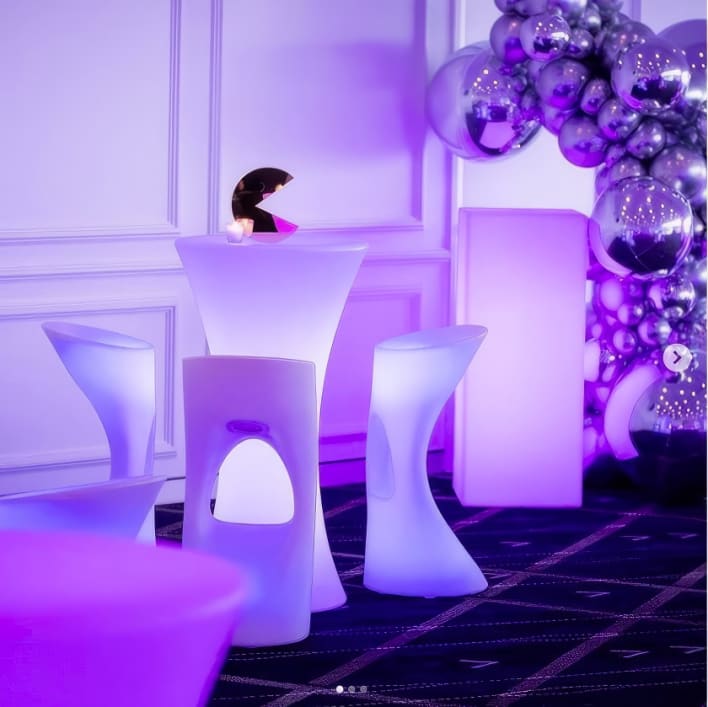 A purple led table and chairs in a party setting.