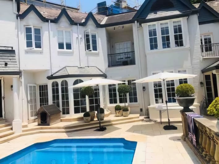 A house with a swimming pool and umbrellas.