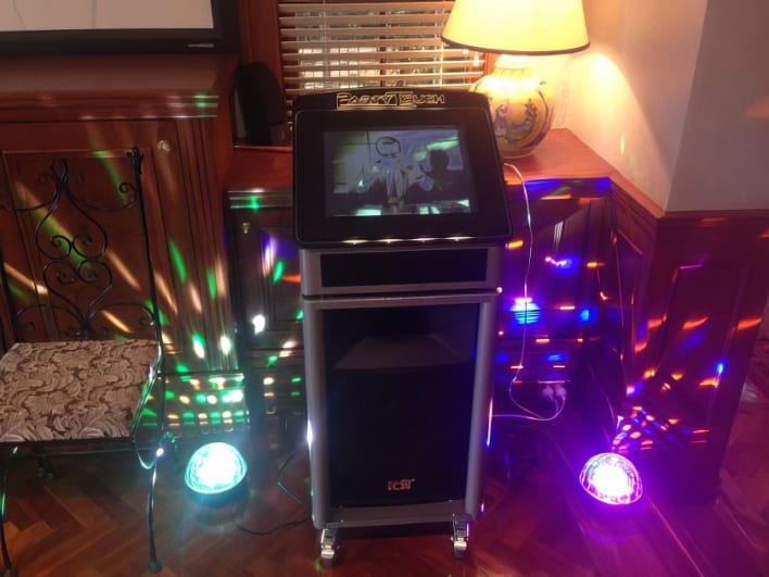 A karaoke machine in a room with colorful lights.