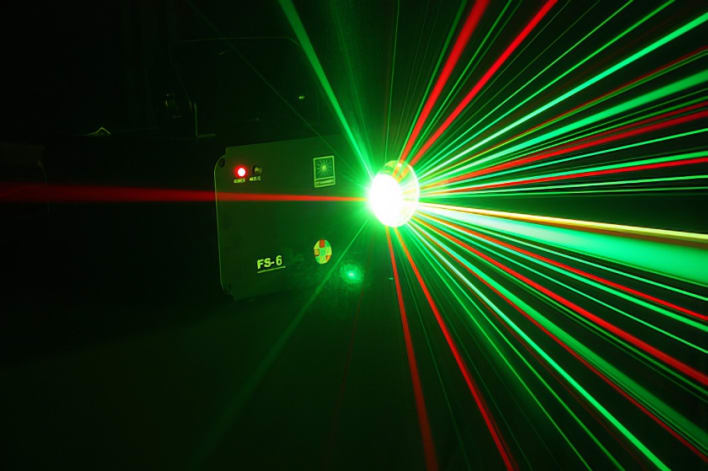 A green and red laser light in a dark room.
