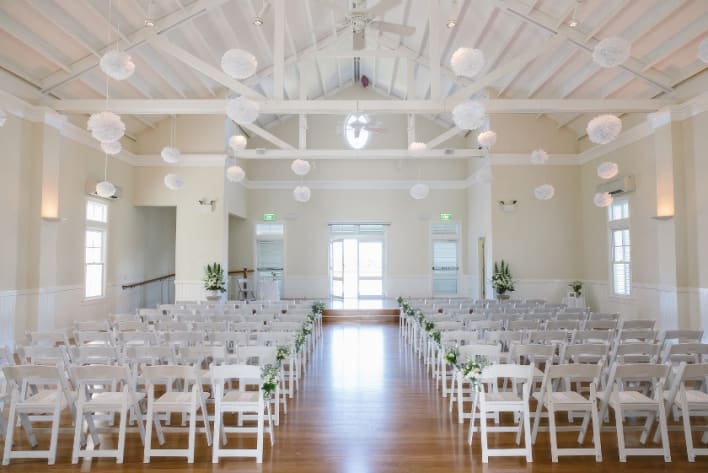 A wedding ceremony with white chairs and paper lanterns.