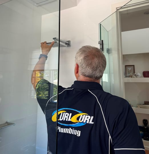 A plumber inspecting a shower head for leaks